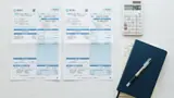 電気とガスの請求内訳を並べて確認する様子